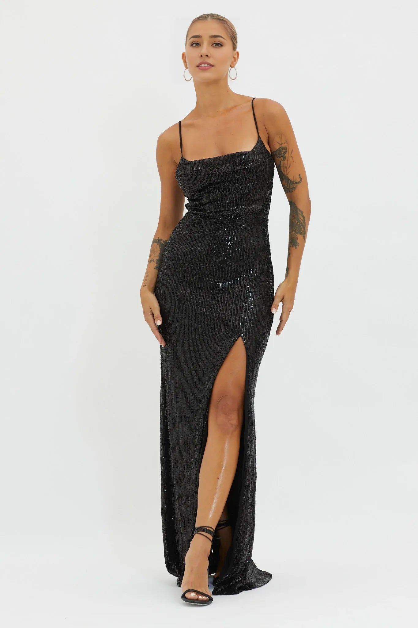 Robe longue chic noire à paillettes avec bretelles spaghetti, col bénitier, fente haute sur la cuisse et ourlet fluide. Robe de bal 