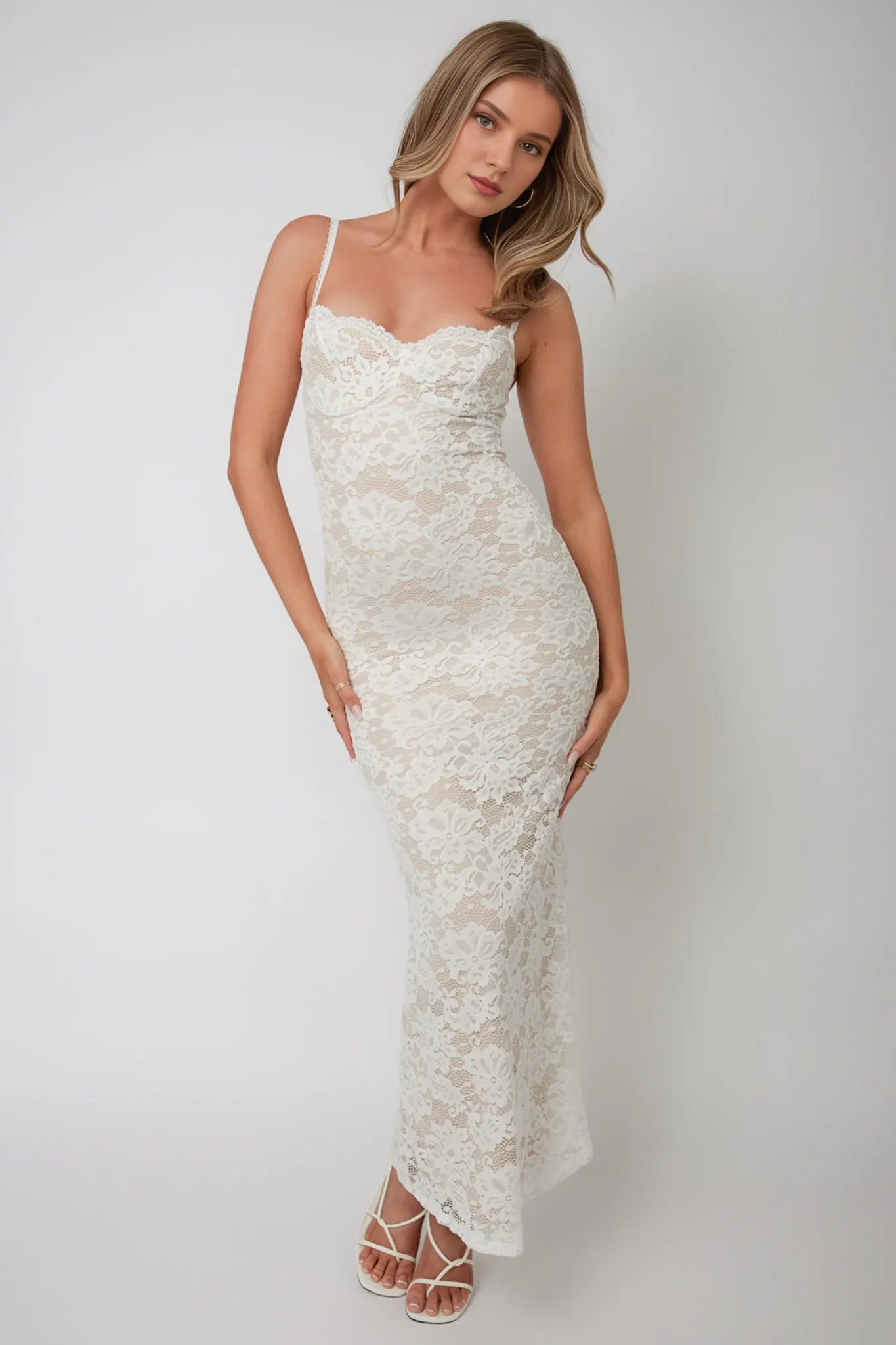 Robe longue chic en dentelle blanche avec bretelles spaghetti, décolleté en cœur et motif en dentelle complexe. Robe de bal 
